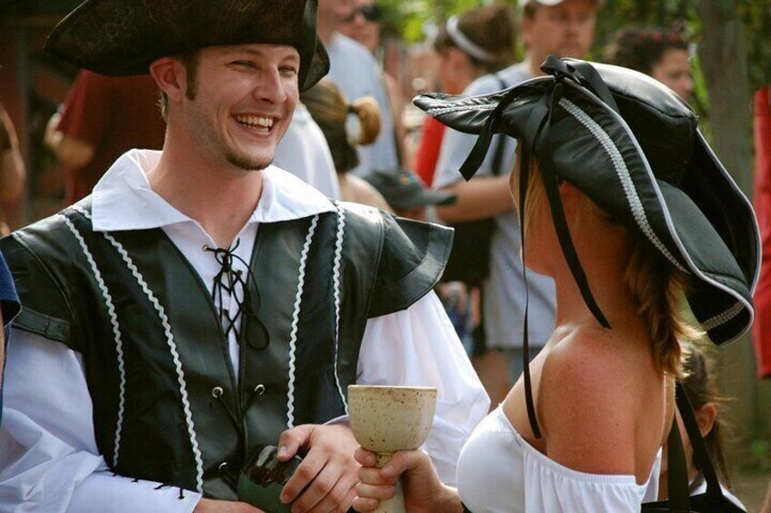 A person in a black and white costume with a hat, holding a bowl. 1