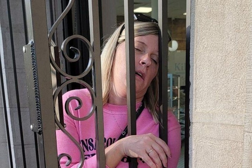 A person peeking through a metal gate with a spiral design. 2