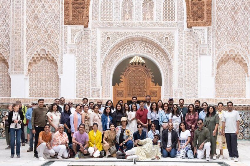A group of people posing in front of a detailed architectural structure with intricate designs. 4