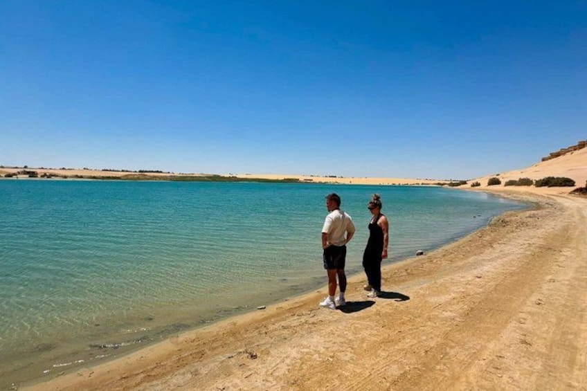 A sandy beach with clear blue water and a clear sky. 2