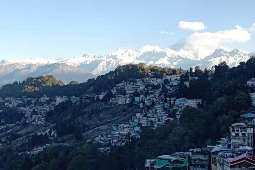 A mountainous village with snow-capped peaks in the background. 4