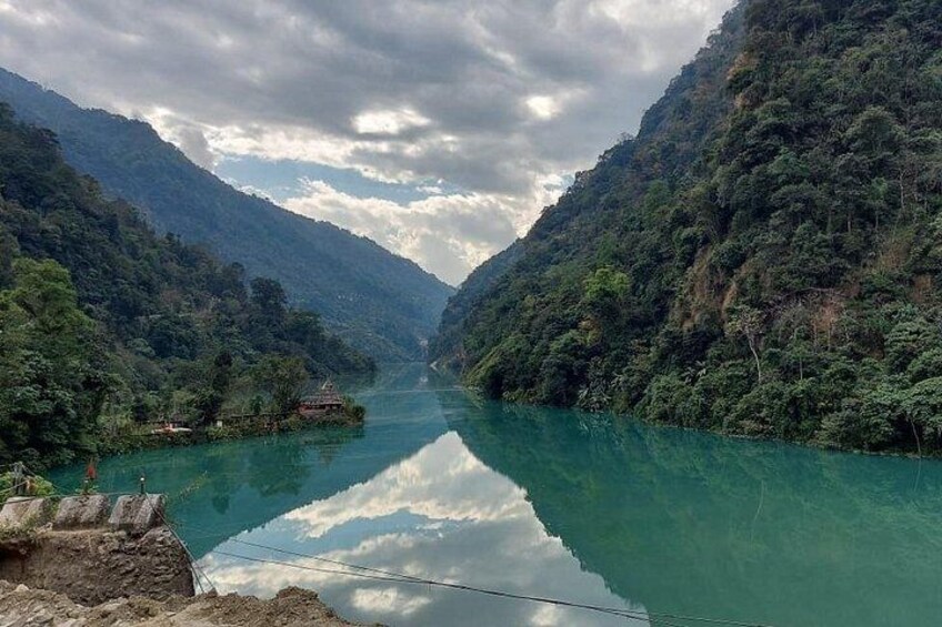 A river valley with dense forested hills and a clear waterway. 4