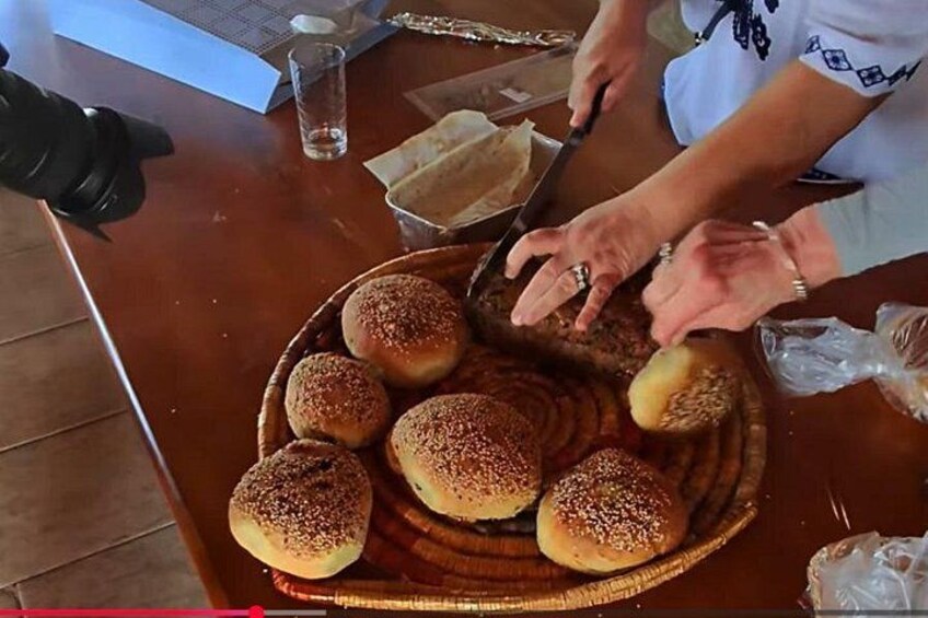 Eine Person schneidet eine Brotlaib auf einem Holztisch. 3