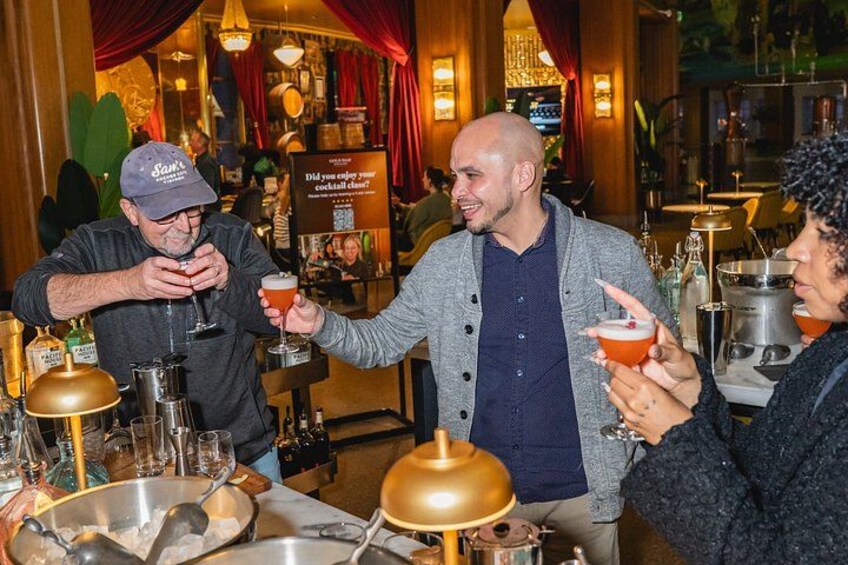 Een barscène met mensen die drankjes vasthouden, een barman en een cocktailkaart. 2