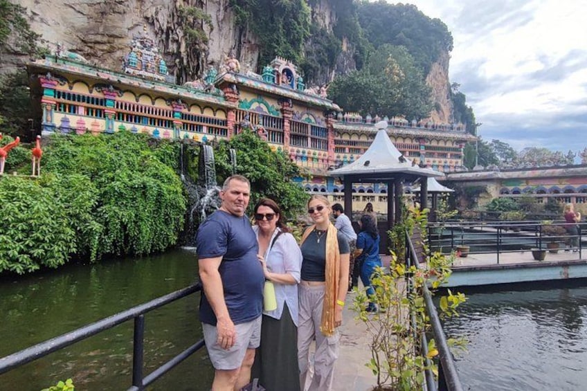 A couple standing by a water body with a temple in the background. 3