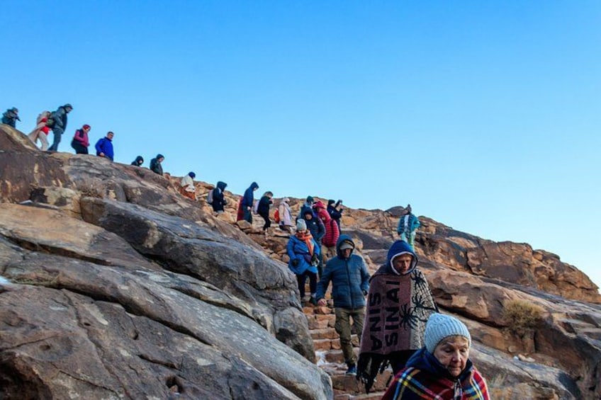 A group of people hiking on a rocky mountain trail. 2