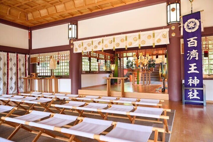 Een traditionele Japanse hal met tatami matten, houten balken en een shimenawa touw. 4