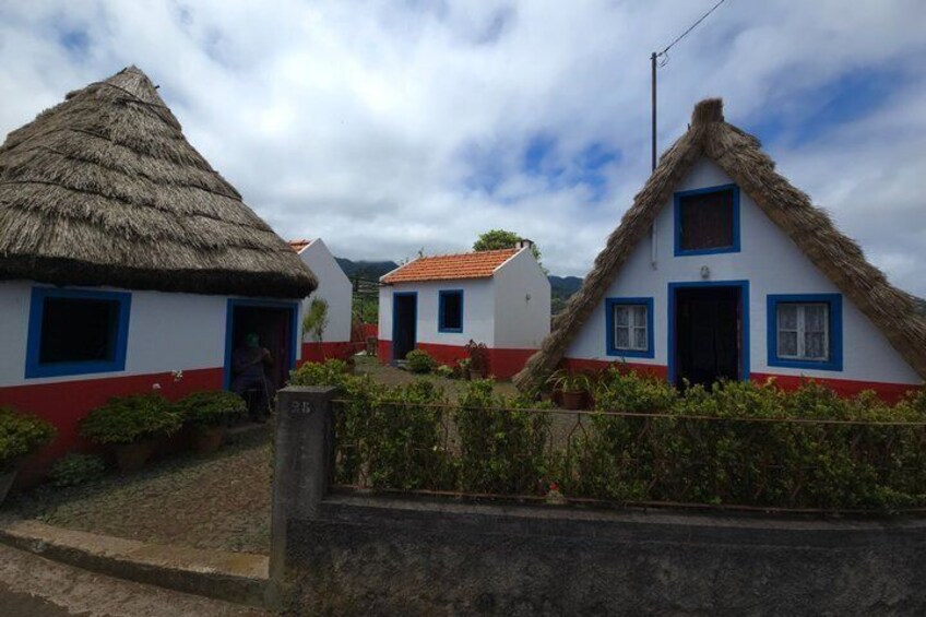 Traditional houses with thatched roofs and white walls with red and blue trim. 4
