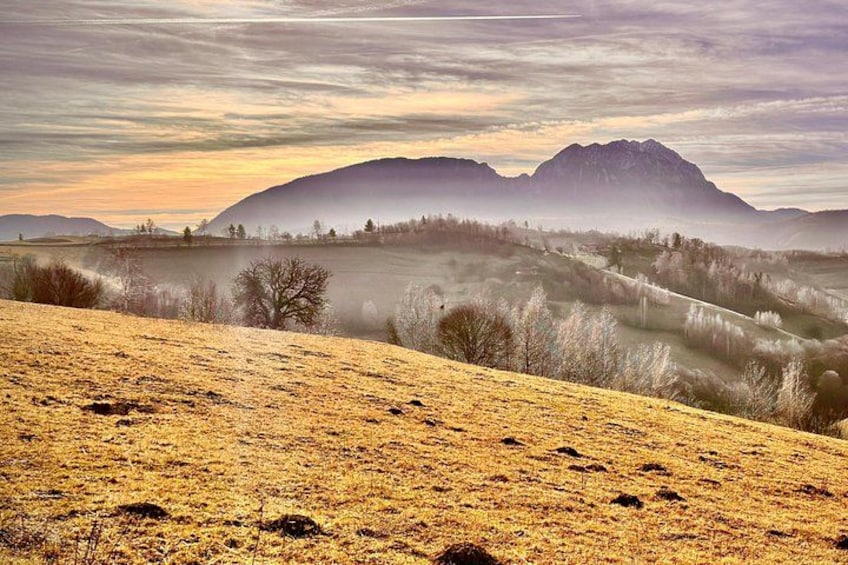 A hilly landscape with a mountain in the background and a clear sky. 4