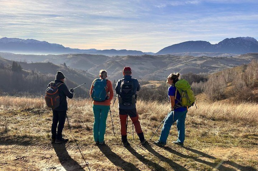 Four hikers on a mountain trail with a panoramic view of the landscape. 1