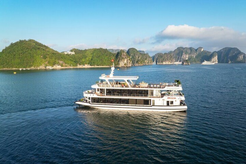 Un bateau à vapeur blanc navigue sur des eaux calmes, avec une chaîne de montagnes en arrière-plan. 3
