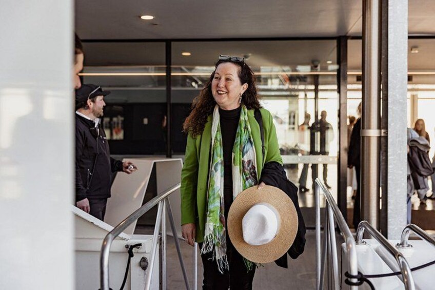 A person with a straw hat walking through a modern building with glass doors and metal railings. 2