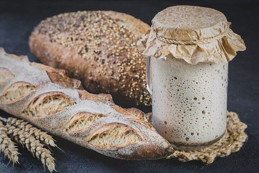 A loaf of bread, a jar of spread, and wheat stalks. 3