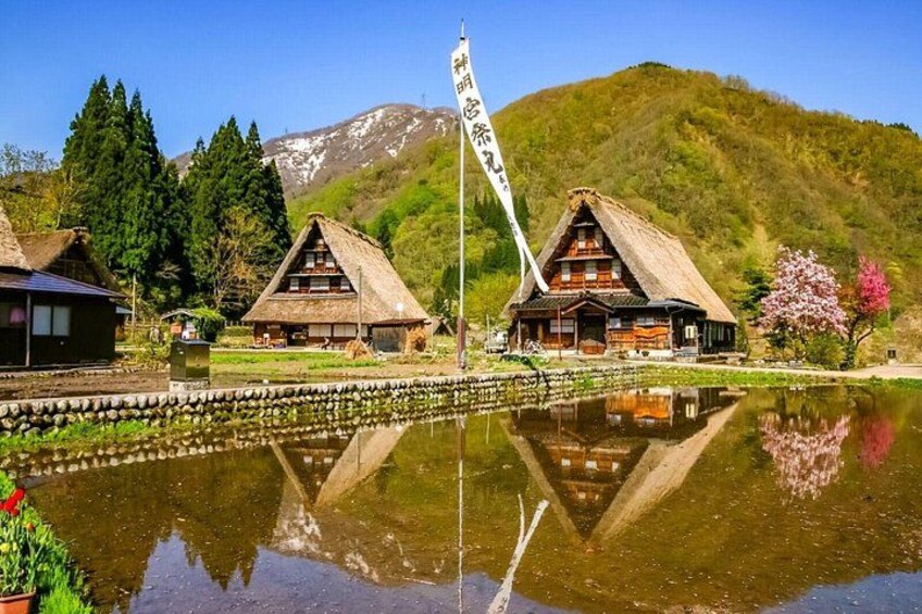 Traditional wooden houses by a calm lake with a mountain backdrop. 3
