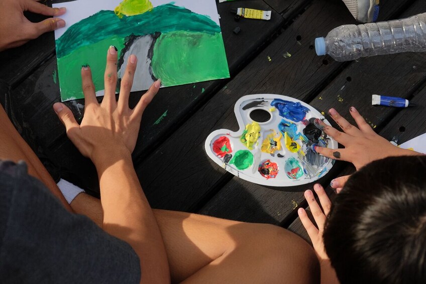 Una persona pinta un paisaje con una paleta de colores. 4