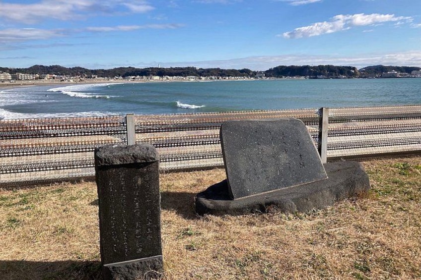 Une zone côtière délimitée par une clôture, ornée d’un monument en pierre, et offrant une vue sur la mer. 2