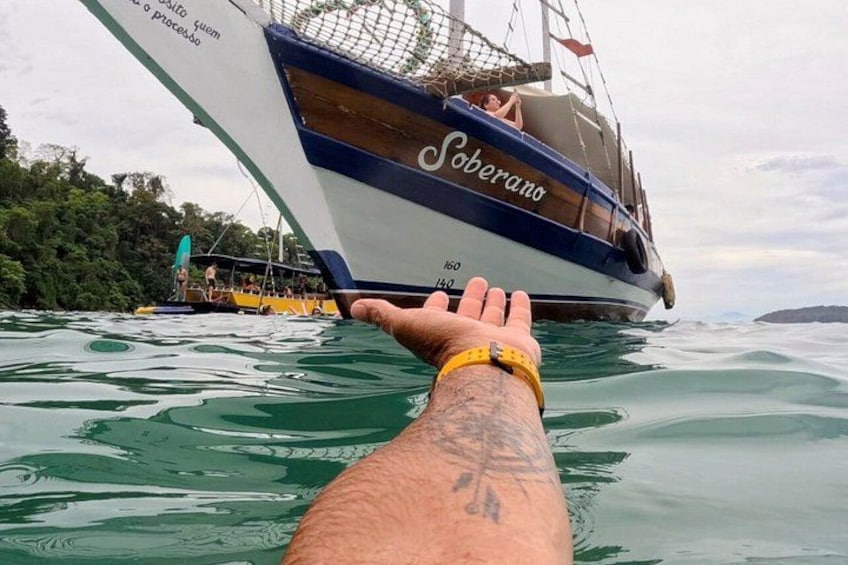 A boat named 'Soberano' with the number 160 on its side, floating on water with a person extending their arm towards it. 1
