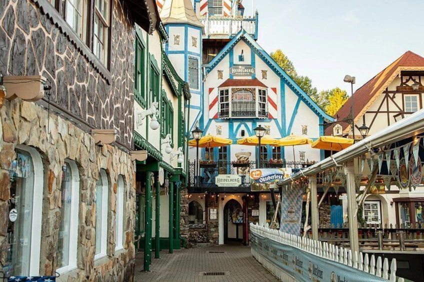 Una calle europea tradicional con edificios coloridos, un jardín de cerveza y un cartel de 'Heineken'. 3