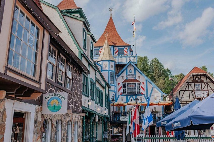 A traditional European street with half-timbered buildings, a sign for Alpine Trading Co., and flags. 5