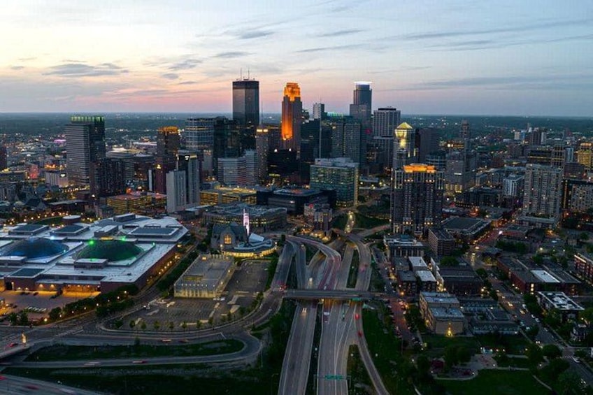 A cityscape with a prominent skyscraper, a highway interchange, and surrounding buildings. 2