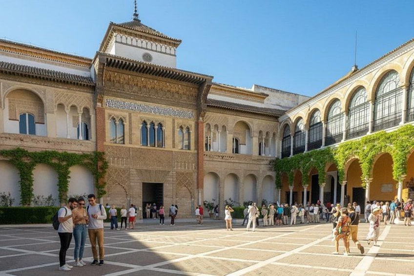 A historic courtyard with arches, a building with intricate facade, and people walking. 2