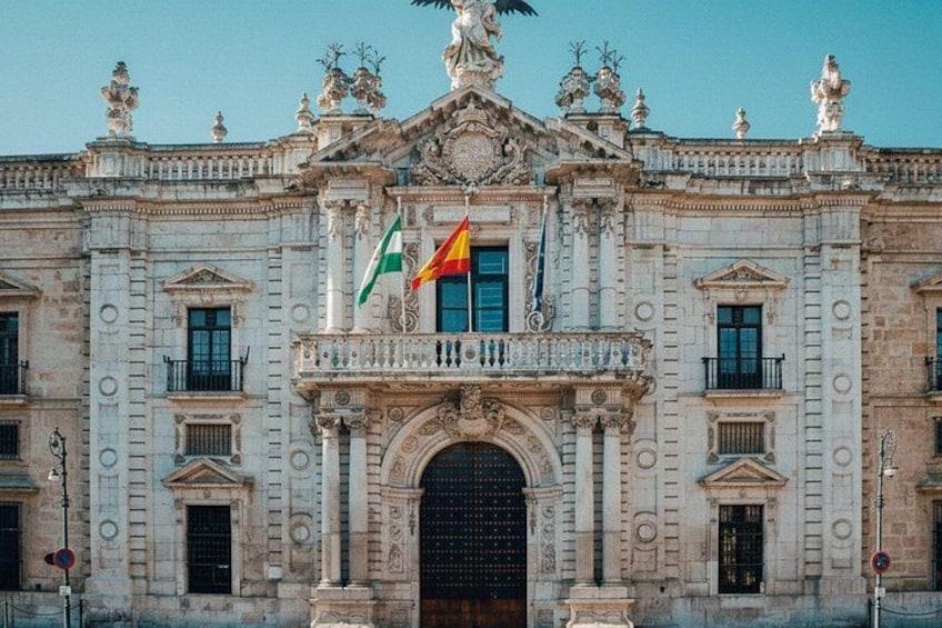 A historic building with ornate architecture, flags, and statues. 4
