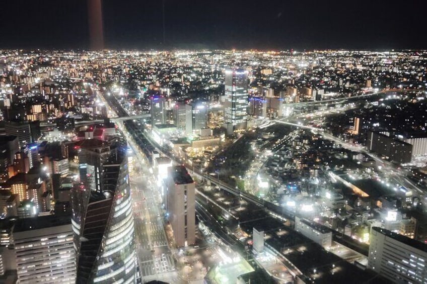 Un paisaje urbano nocturno con edificios iluminados y calles concurridas. 2