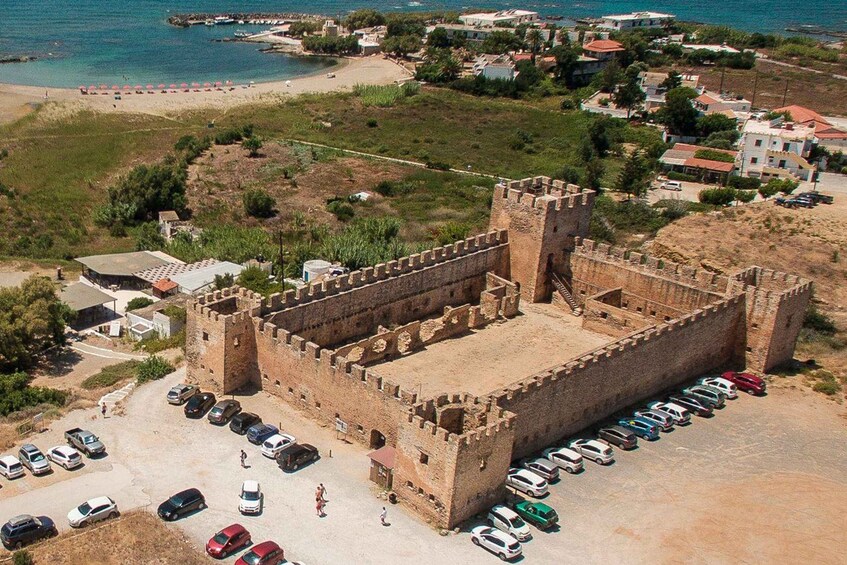 A castle surrounded by a parking lot and a beach. 4