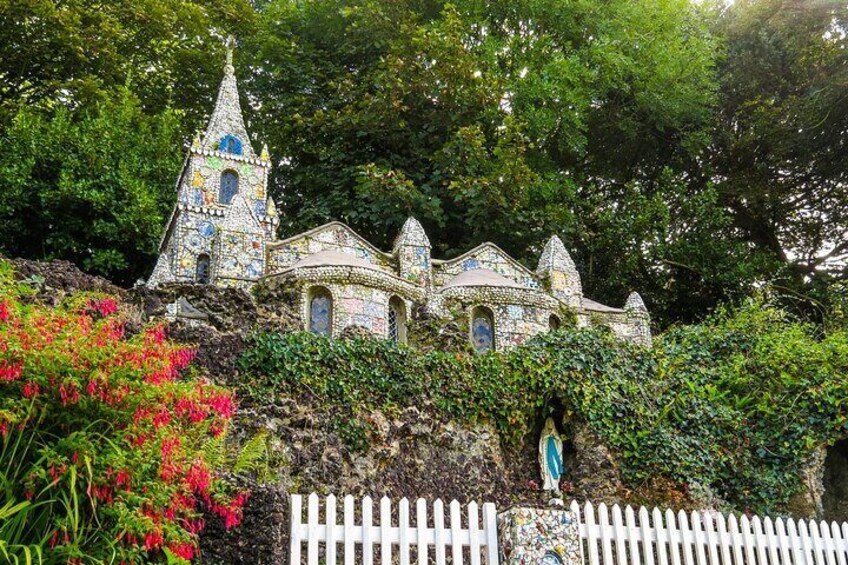 Une église aux couleurs vives, ornée d’une mosaïque, avec une petite clôture blanche devant. 4