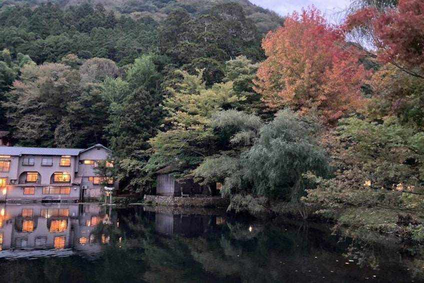 Une maison traditionnelle japonaise située au bord d’un lac paisible, entourée d’un paysage automnal aux couleurs flamboyantes. 2