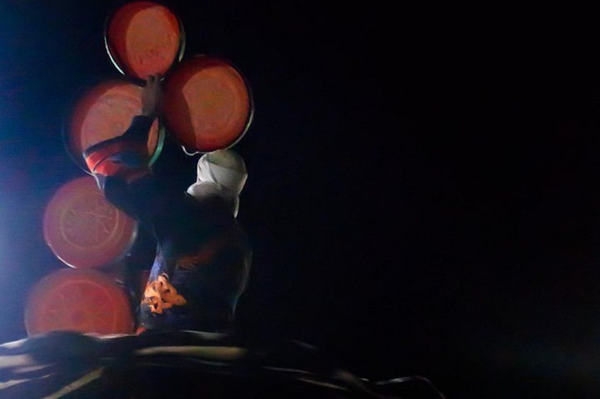 A person juggling multiple large, round objects. 2