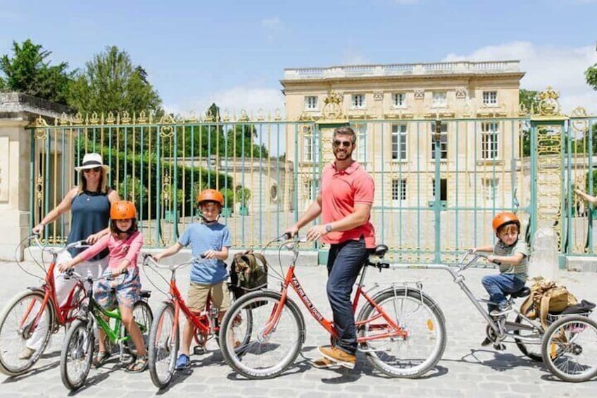 Een groep mensen op fietsen voor een groot, versierd gebouw. 4