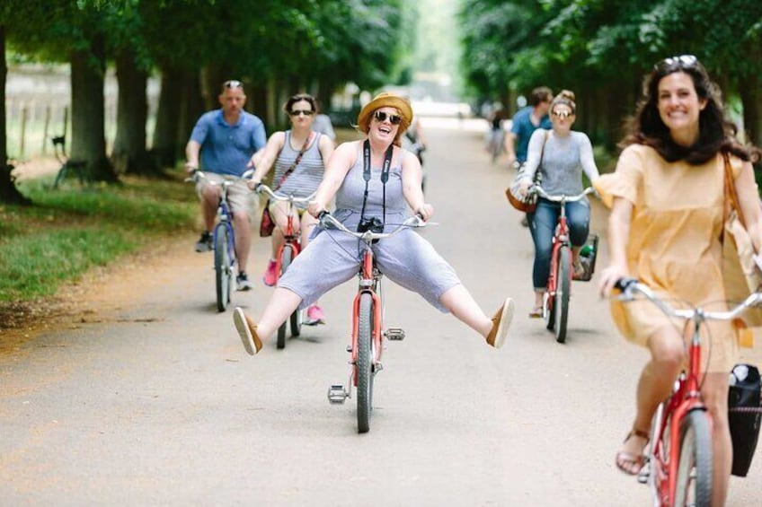 Mensen fietsen op een pad omringd door bomen. 3