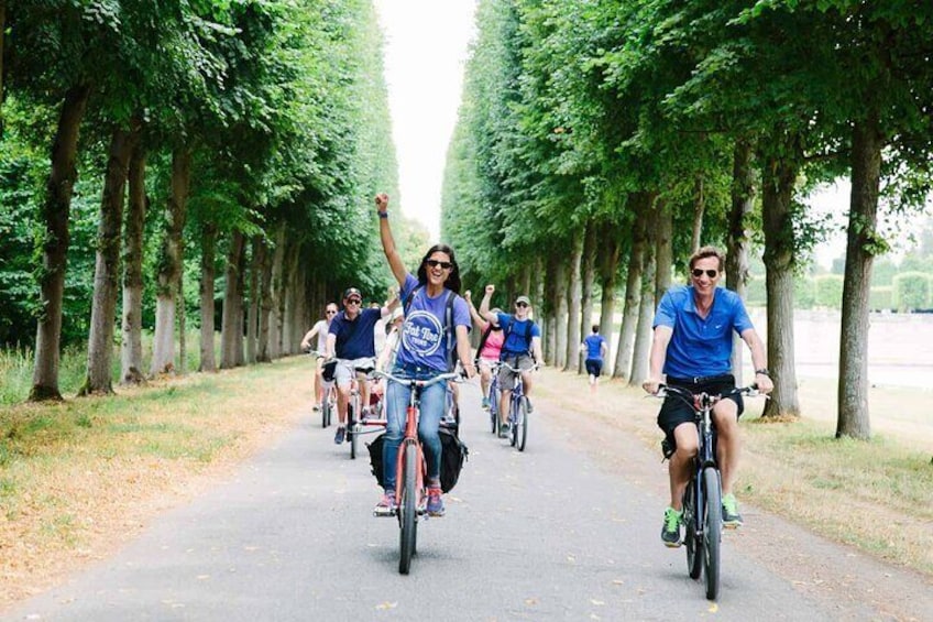 Een groep mensen fietst op een pad met bomen. 2