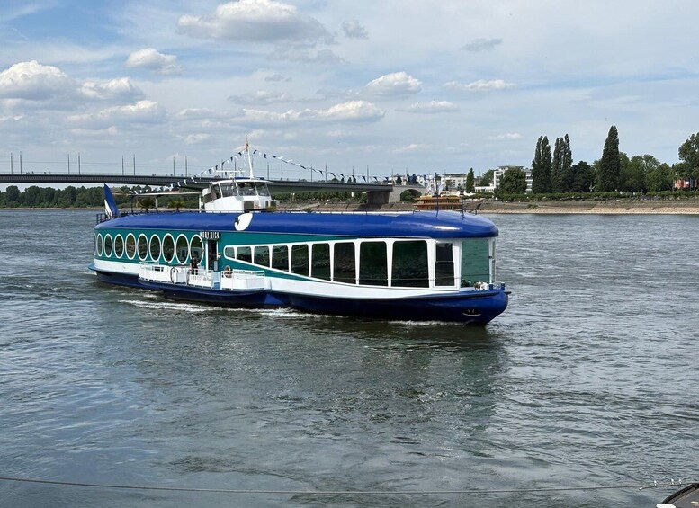 A blue and white riverboat with a bridge in the background. 2