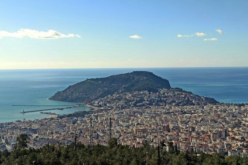 A coastal cityscape with a prominent hill and a pier extending into the sea. 4
