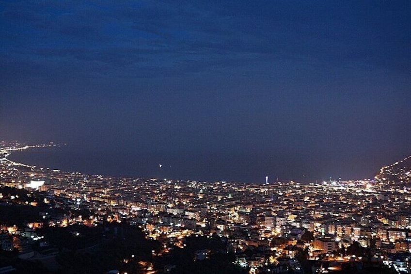 A nighttime cityscape with a coastline. 5