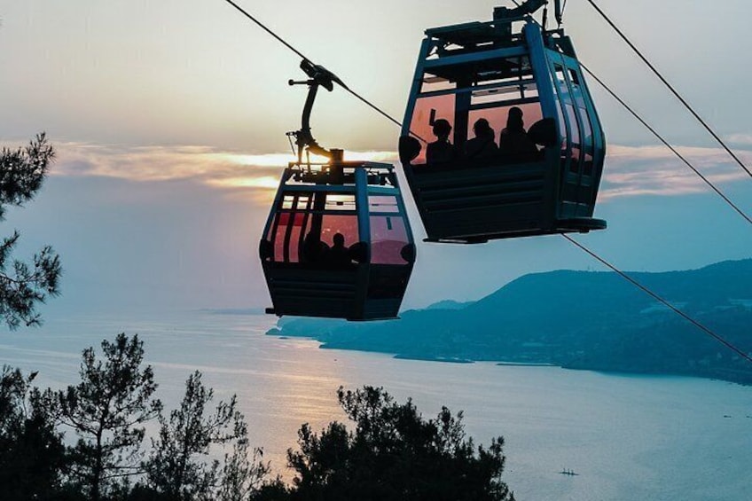Two cable cars suspended over a body of water with a mountainous backdrop. 2
