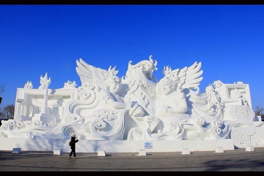 A large white sculpture of a mythical creature with wings and a dragon. 3