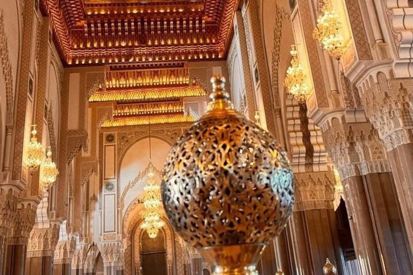An ornate interior with intricate architectural details, including a large decorative lamp and chandeliers. 5