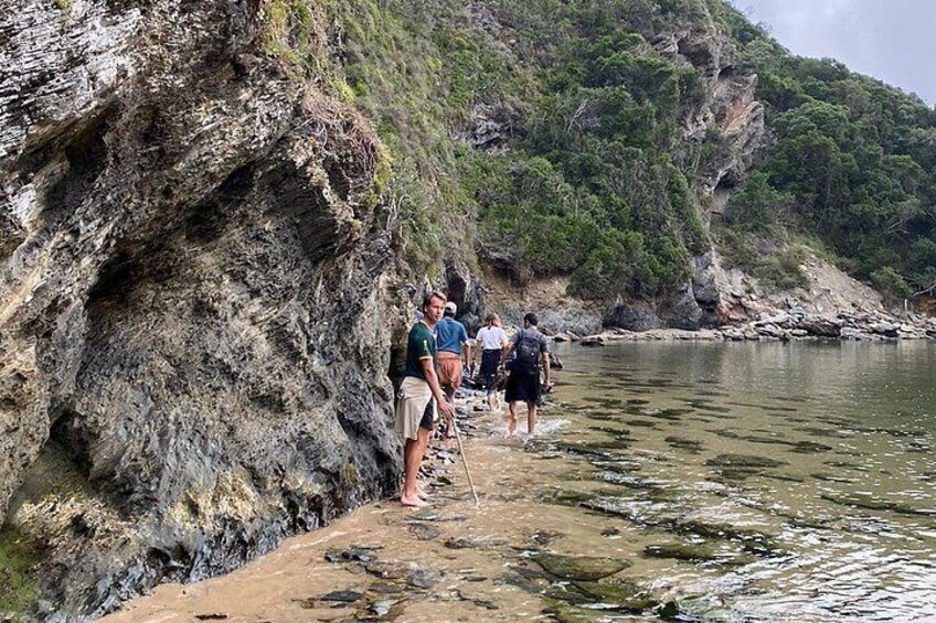 A rocky shoreline with people walking along it. 3