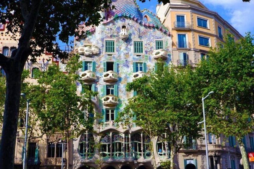 Un bâtiment aux couleurs vives, doté d’une architecture originale, et entouré d’arbres. 2