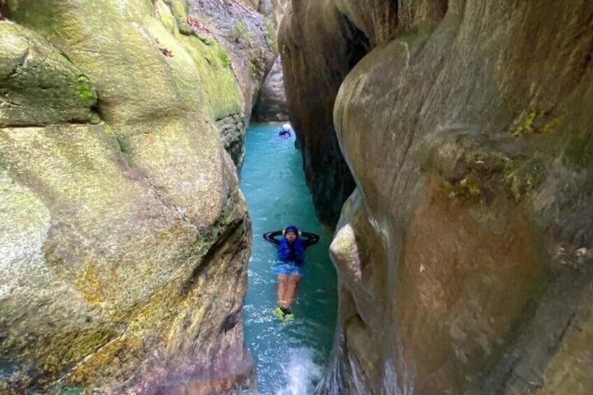 Eine Person schwimmt in einer schmalen Schlucht mit steilen Felswänden. 4