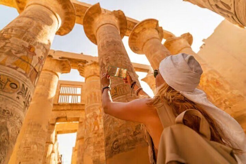 Eine Person fotografiert alte ägyptische Säulen mit Hieroglyphen. 1