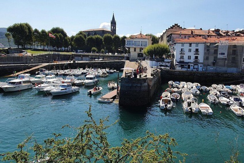 Un port où de nombreux bateaux sont amarrés, un pont de pierre et des bâtiments en arrière-plan. 4