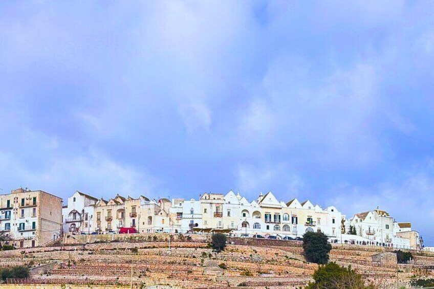 A coastal town with terraced buildings and a clear sky. 4