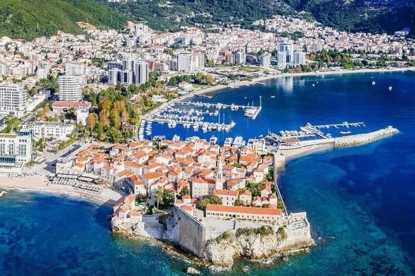 A coastal city with a historic fort, a marina, and residential buildings. 4