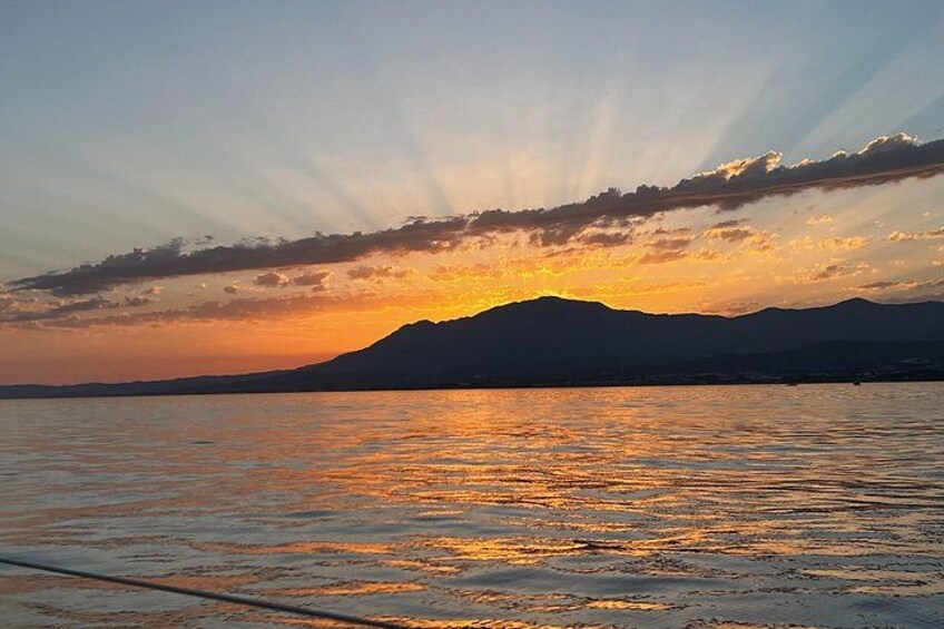 A sunset over a body of water with mountains in the background. 4