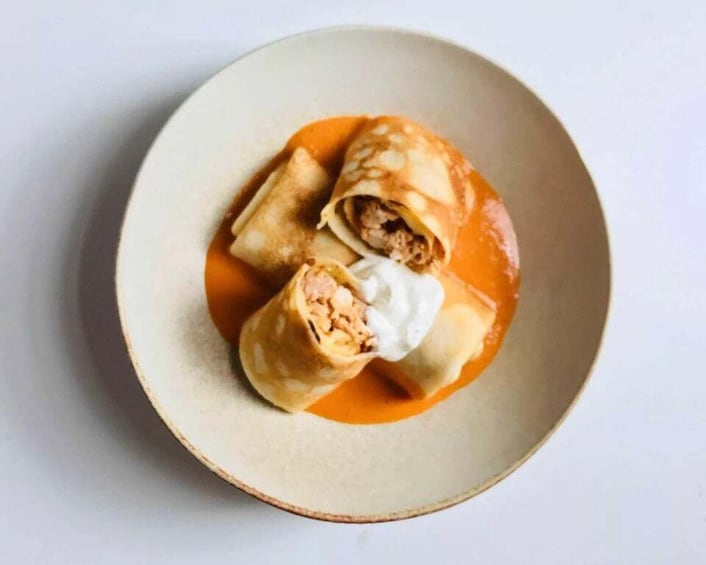 Three rolled dumplings on a plate with a tomato-based sauce. 3
