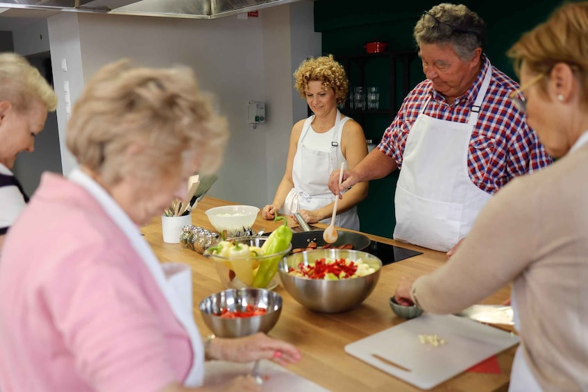 A group of people cooking together in a kitchen. 4